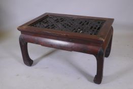 A Chinese stained wood coffee table with a pierced geometric design to the top, 33" x 22", 18" high