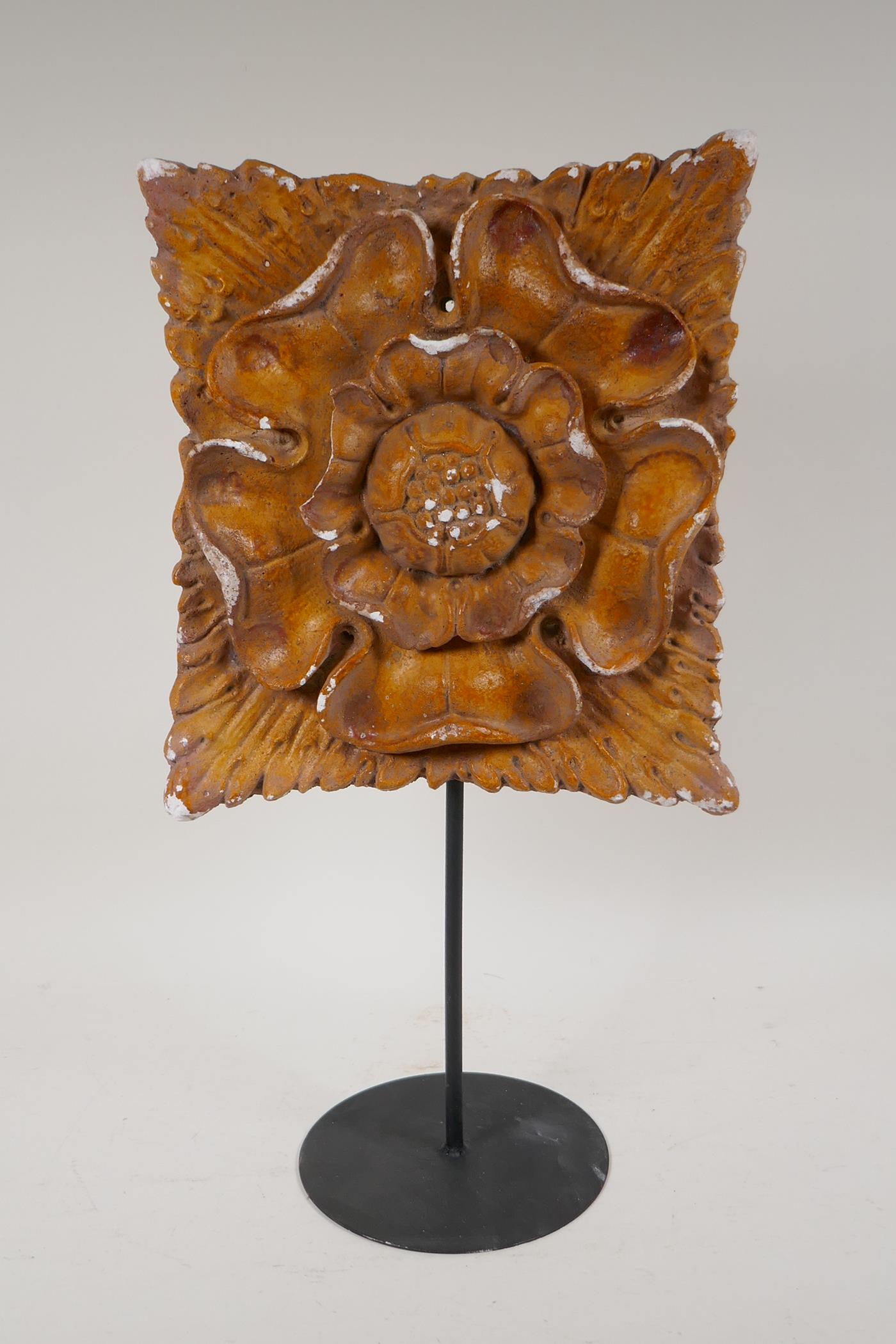 A painted plaster Tudor Rose plaque in relief, on a display stand, AF, 18" high, plaque 10" x 10"