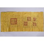 A Chinese gilt silk scroll with printed calligraphy decorations, paper backed and crumpled, 36" x