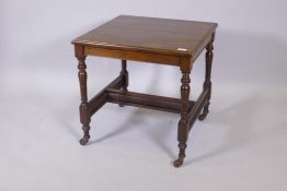 A Victorian walnut occasional table raised on turned tapering supports united by 'H' stretchers with