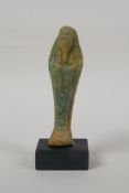 An Egyptian turquoise glazed faience shabti, mounted on a display base, 5" high