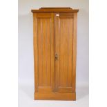 A walnut linen cupboard with two tongue and groove panelled doors, the interior fitted with