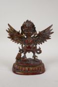 A Tibetan gilt and coppered bronze figure of Garuda, 7" high