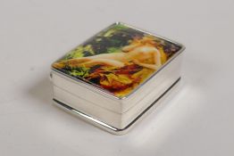 A sterling silver pill box set with a cold enamel plaque depicting a female nude, 1" x 1½"