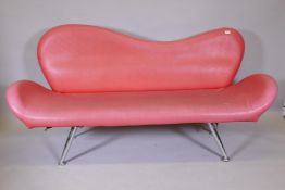 A 1960s style red leatherette shaped back settee on chrome supports, 72" long