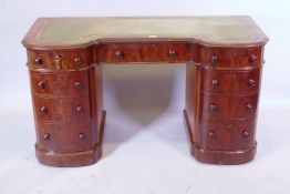 A Victorian nine drawer figured mahogany pedestal desk, with inset leather top and inverted front