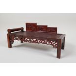 A Chinese carved hardwood miniature day bed, 9" x 4"