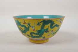 A polychrome porcelain rice bowl with green dragon decoration on a yellow ground, the interior of