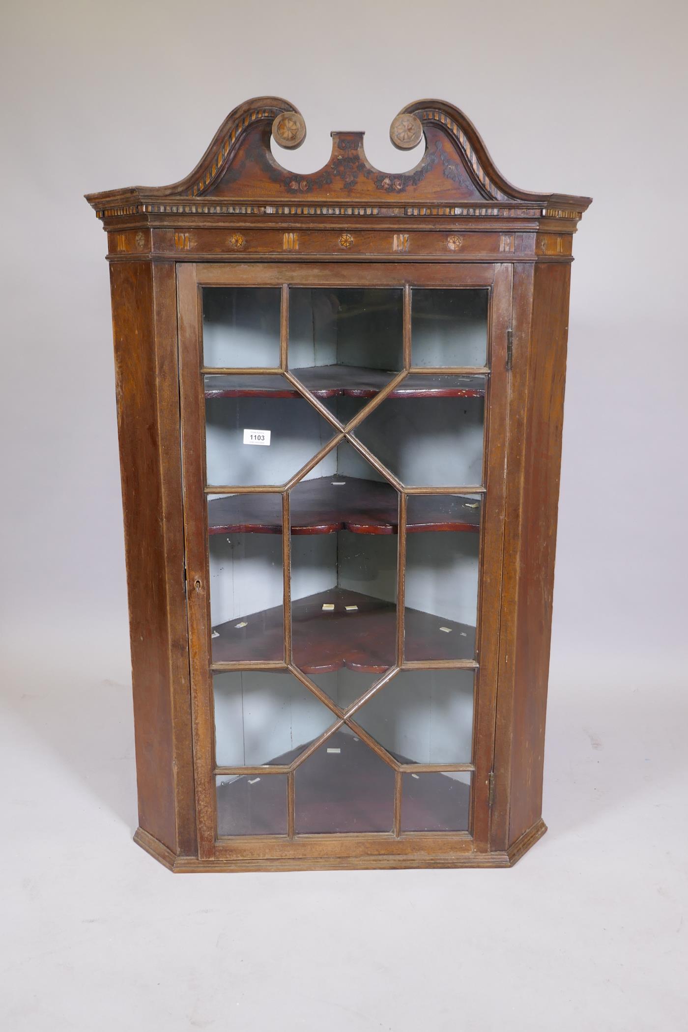 A C19th mahogany hanging corner cupboard with an astragal glazed door, with painted and inlaid