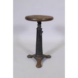 An early C20th industrial cast iron Singer sewing machinist factory stool, with wooden button seat