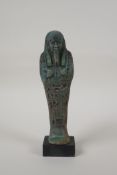 An Egyptian turquoise glazed faience shabti, mounted on a display base, 7" high