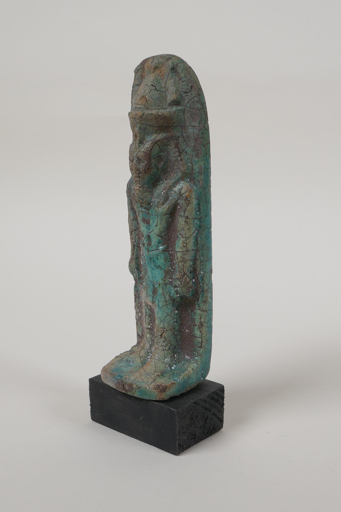 An Egyptian turquoise glazed faience shabti, mounted on a display base, 5" high - Image 4 of 4
