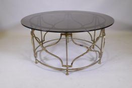 A wrought metal and tinted glass top centre table, AF minor chip to edge, 43" diameter, 20" high