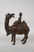A West China gilt bronze figure of a Tang style lady riding a camel, 8½" high