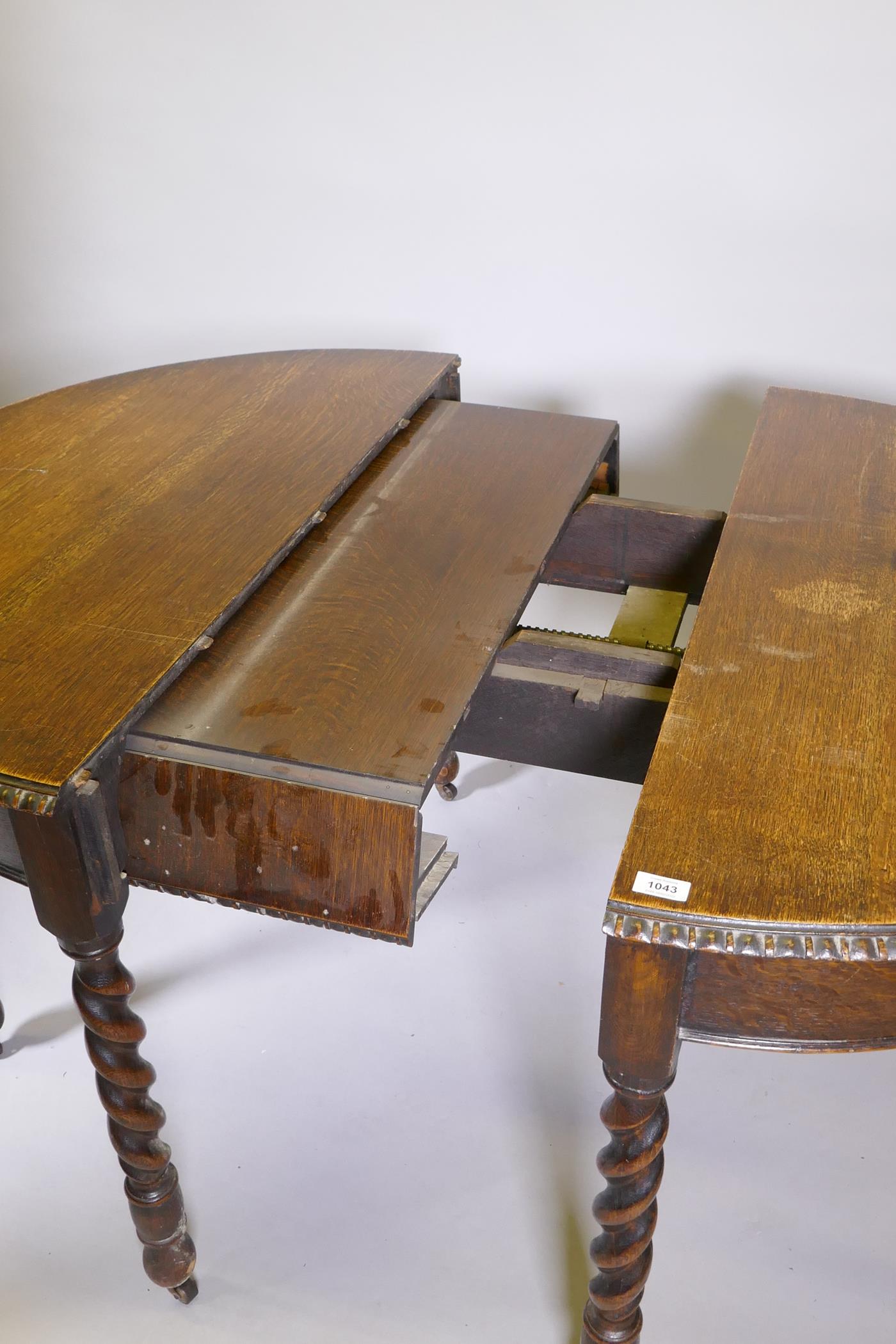 An early C20th oak wind out dining table, raised on eight handed barleytwist supports, with extra - Image 4 of 6