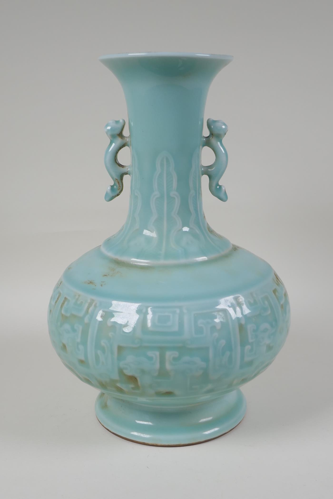 A celadon glazed porcelain vase with two kylin shaped handles and archaic style underglaze dragon