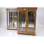 A pair of two door illuminated contemporary display cabinets with granite tops, mirrored backs,