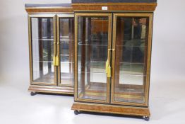 A pair of two door illuminated contemporary display cabinets with granite tops, mirrored backs,