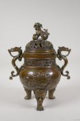 A Chinese bronze censer on tripod supports, with two dragon shaped handles, temple lion knop and