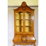 A continental bombe shaped burr walnut display cabinet, the upper section with two glazed doors, the