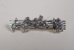 A sterling silver brooch decorated with avian musicians, 2" long