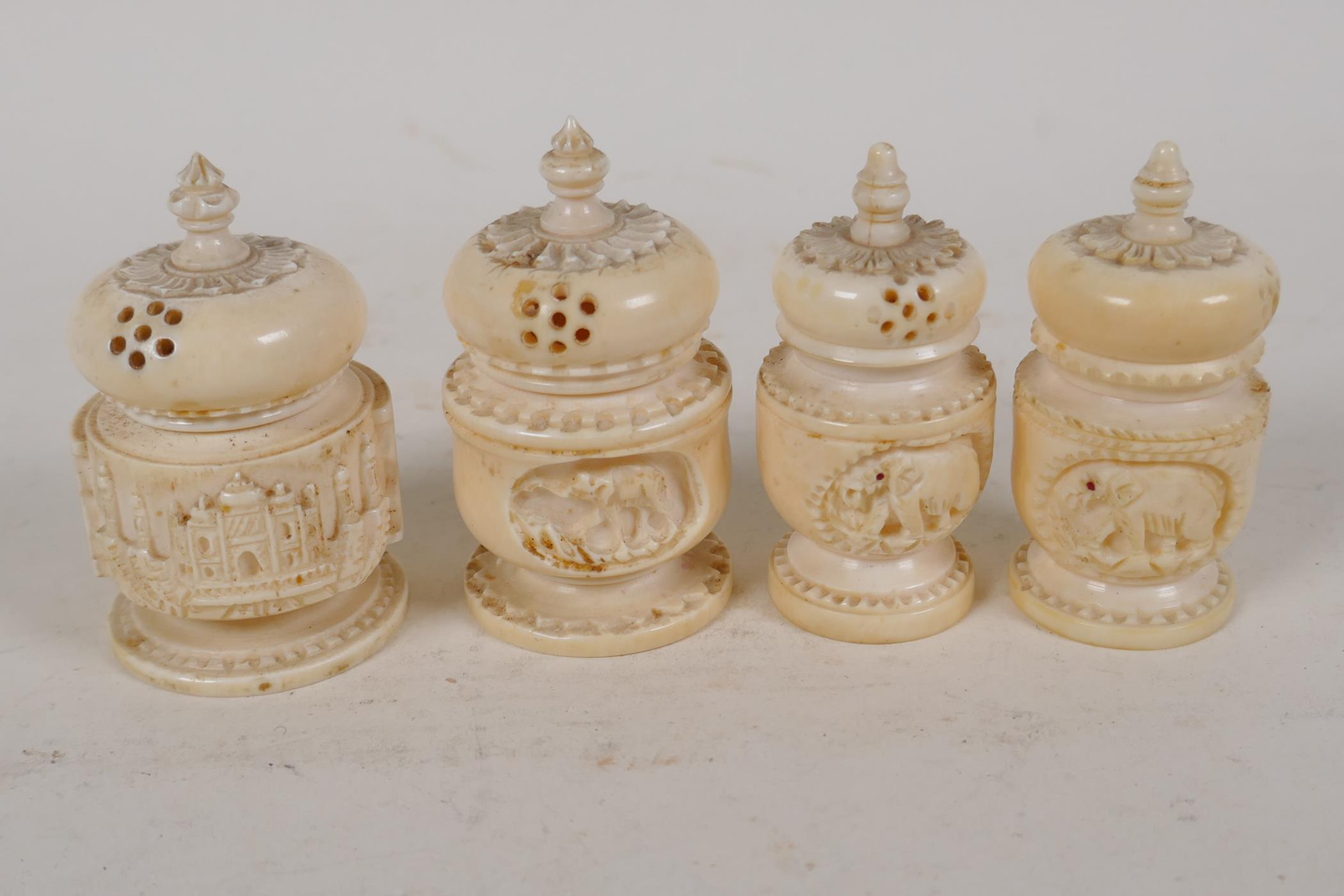 An Indian ivory cruet carved as temple towers, 2" high, and a similar smaller cruet