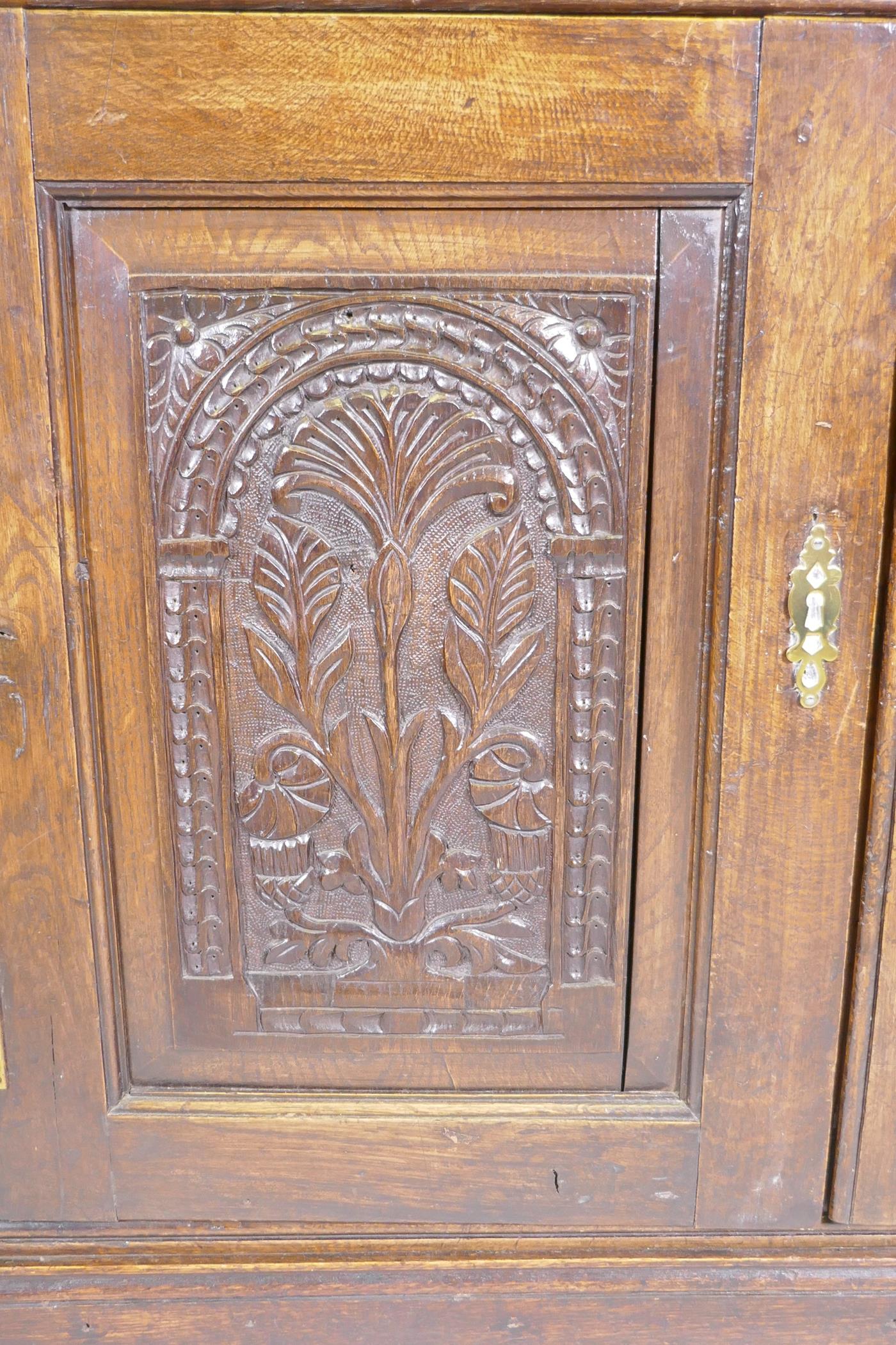 An antique oak corner cabinet with two glazed doors over two doors with carved panels, adapted, - Image 2 of 5