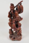 An oriental rootwood carving of a fisherman with a young boy, and his catch, 12" high