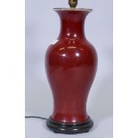 A Chinese porcelain vase table lamp with sang de boeuf glaze, mounted on a wood base, 16" high