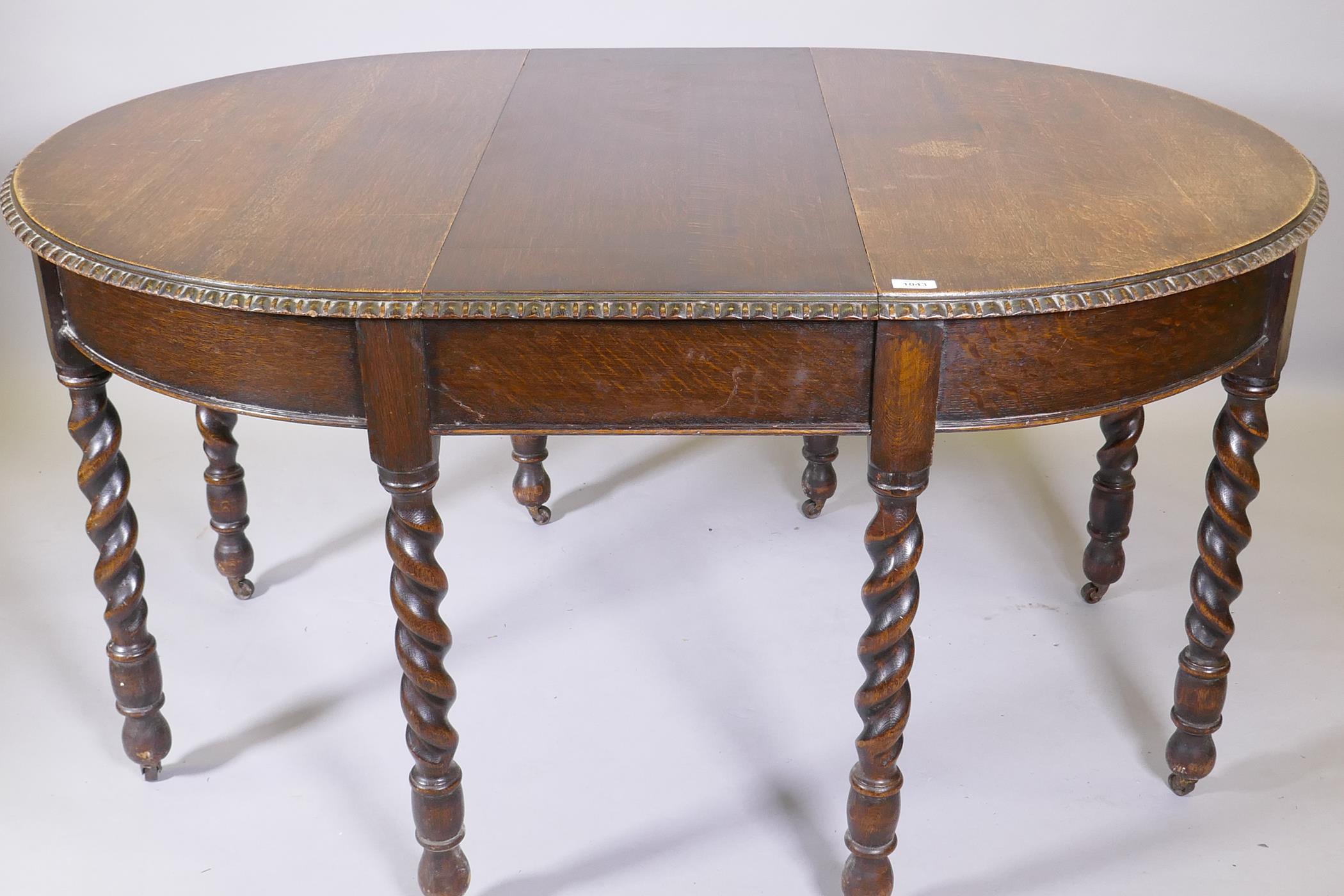 An early C20th oak wind out dining table, raised on eight handed barleytwist supports, with extra - Image 5 of 6