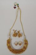 An Indian gilt metal necklace with enamelled detail, and set with red semi precious stones, together