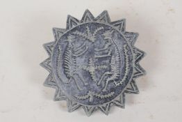 A carved stone seal in the form of a 17-point star, engraved with two mythical creatures, 4"