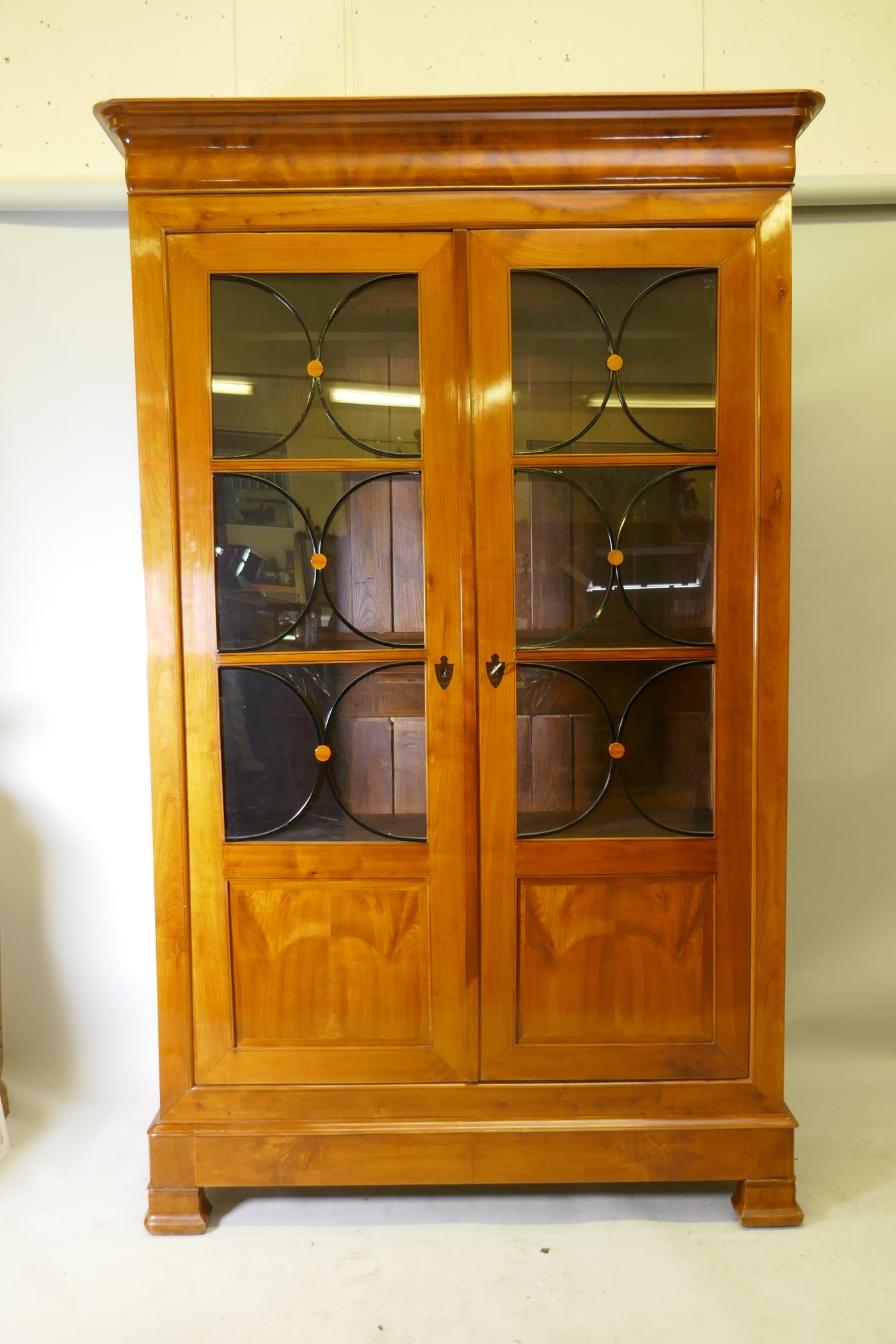 A C19th Continental Biedermeier style fruitwood armoire, with ebony stringing, the doors later