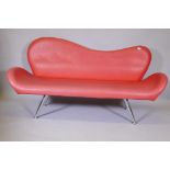 A 1960s style red leatherette shaped back settee on chrome supports, 72" long