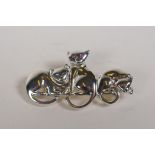 A sterling silver brooch in the form of three cats with ruby set eyes, 1½" long