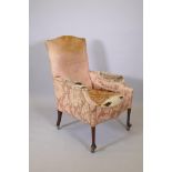 A Victorian armchair raised on mahogany supports with pad feet