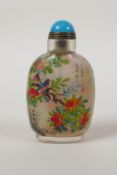 A Chinese reverse decorated glass snuff bottle depicting birds amongst branches bearing fruit and