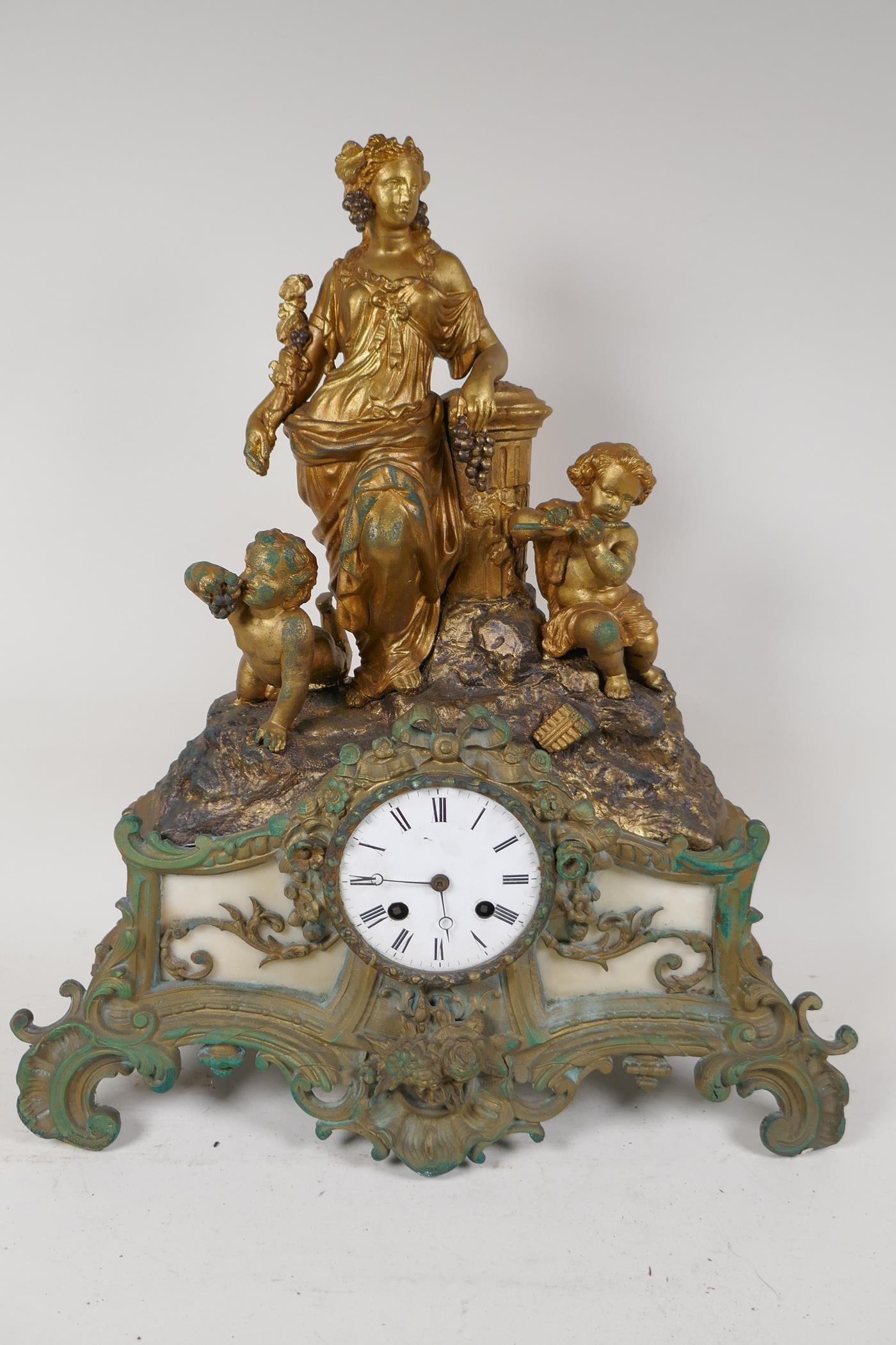 A C19th French spelter mantel clock adorned with Baccanalian figures, with twin train movement