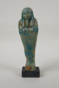 An Egyptian turquoise glazed faience shabti, mounted on a display base, 7" high