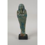 An Egyptian turquoise glazed faience shabti, mounted on a display base, 7" high