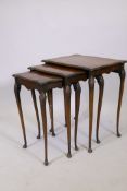 A nest of three walnut tables with shaped tops, raised on cabriole supports