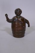 An antique bronze hand bell in the form of a boy in a barrel, 5" high