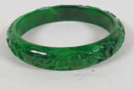 A green jade bangle carved with a fruiting vine, 2½" diameter