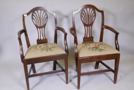 A pair of mahogany Hepplewhite elbow chairs with drop in needlework seats, shaped back and pierced