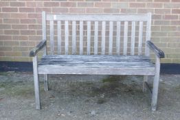 A weathered teak garden bench, 49" wide