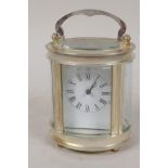 An oval time piece carriage clock in silver plated case with white enamel dial and Roman numerals,
