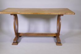 An antique elm refectory table with single plank top, raised on shaped end supports united by a