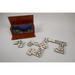 An antique bone and ebony domino set with brass pins, in a fitted box