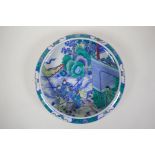 A famille verte porcelain dish with a rolled rim, decorated with warriors on horseback, Chinese