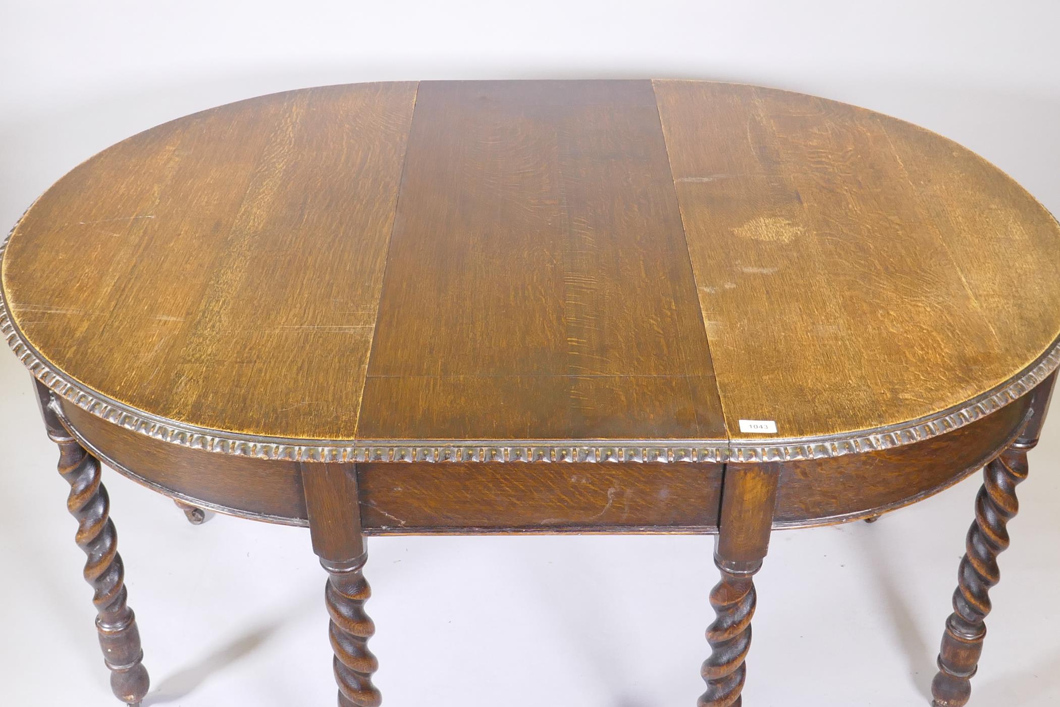 An early C20th oak wind out dining table, raised on eight handed barleytwist supports, with extra - Image 6 of 6